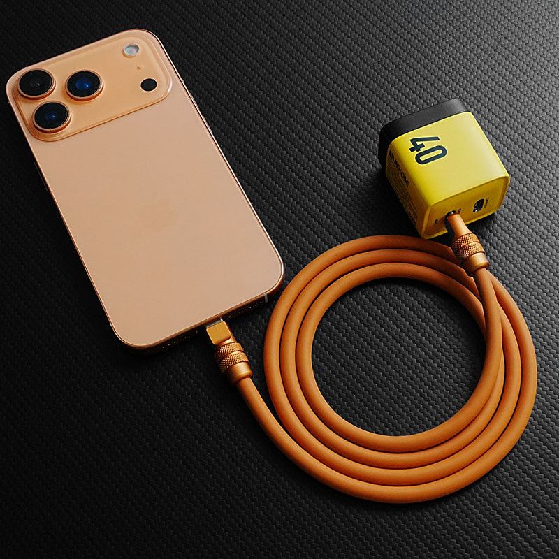 Orange Chubby Cable 240W silicone cable charging an iPhone 17 with a power adapter, demonstrating usage.