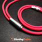 Close-up of heavy-duty metal connector on a thick red silicone cable