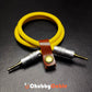 Coiled yellow audio cable secured with brown leather organizer button