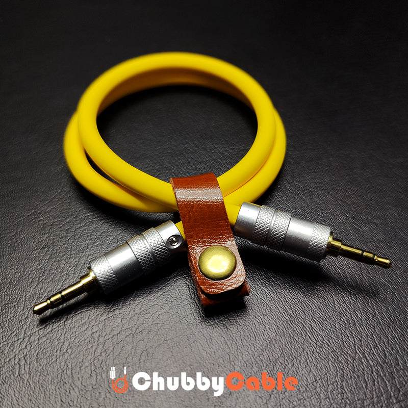 Coiled yellow audio cable secured with brown leather organizer button