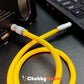 Yellow aux cord plugged into a portable speaker audio input port