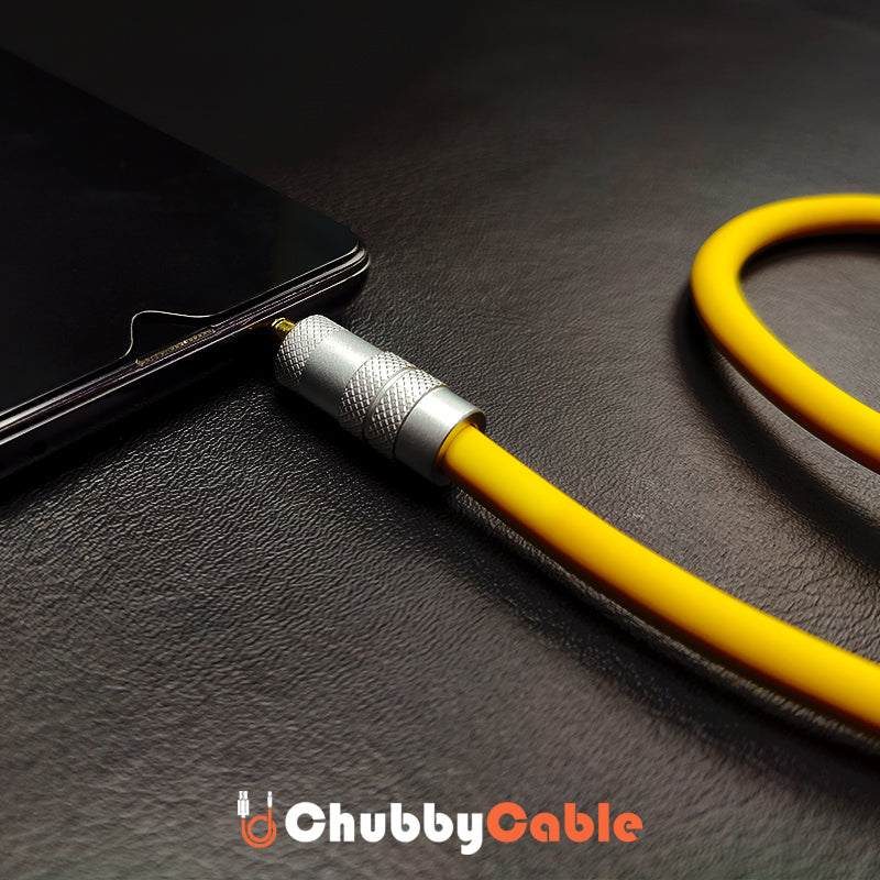 Thick yellow 3.5mm headphone jack adapter plugged into smartphone