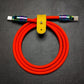 Orange silicone USB-C to USB-C charging cable with iridescent rainbow metal ends.
