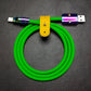 Green silicone USB to USB-C charging cable with rainbow metal connectors and yellow leather strap.