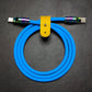 Vibrant blue silicone USB-C to USB-C charging cable with oil-slick metal finish.
