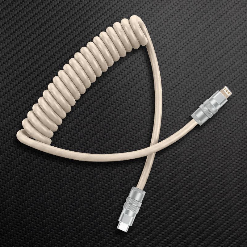 Beige coiled USB-C to Lightning cable for custom desk setups.