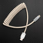 Beige coiled lightning to USB cable on black background