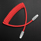 Red coiled USB Type-C charging cable on carbon fiber background