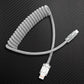 Grey coiled USB to Type-C cable on carbon fiber background