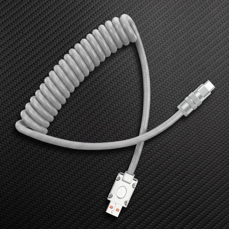 Grey coiled USB to Type-C cable on carbon fiber background