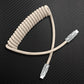Beige coiled USB-C to USB-C cable with silver metal connectors.