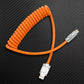 Orange coiled USB to Lightning cable on carbon fiber background