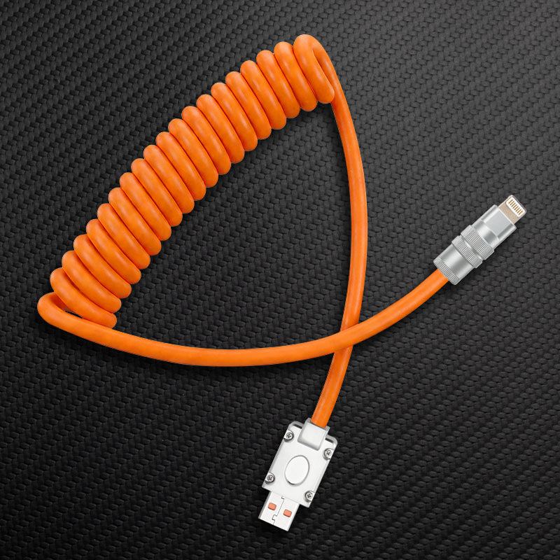 Orange coiled USB to Lightning cable on carbon fiber background