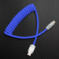 Blue coiled USB to Lightning cable on carbon fiber background