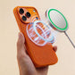 Magnetic wireless charger snapping onto orange phone case.