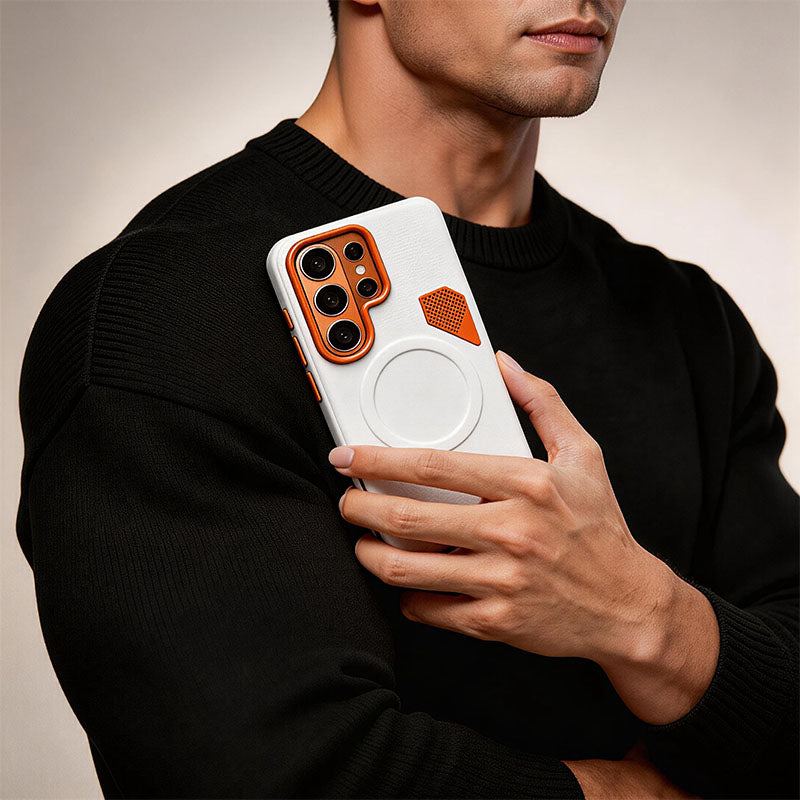 Person holding a white leather-style phone case with orange detail in a black sweater.