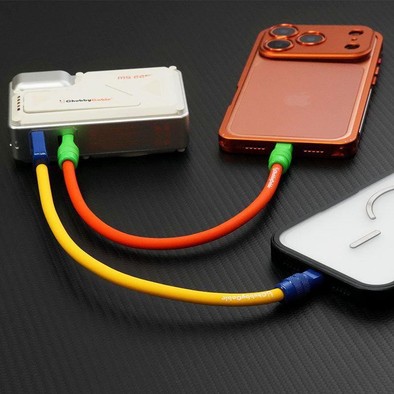 Dual phones charging from one power bank with colorful Chubby Cables.