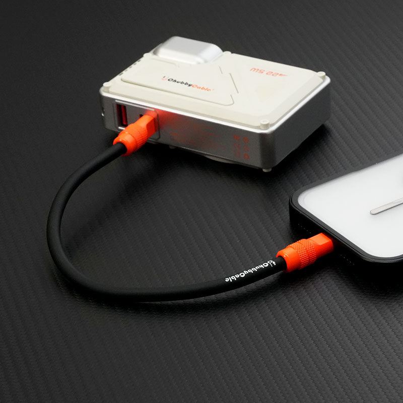 ChubbyCable black silicone short cable connecting a power bank to a smartphone