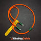 Orange silicone USB-C cable with green accents and leather strap