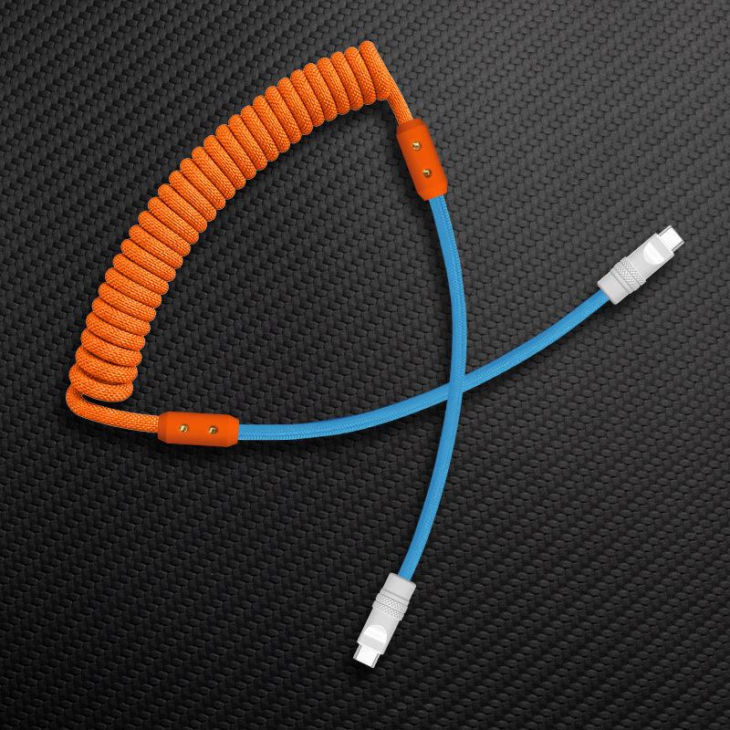 Orange coiled USB-C cable with light blue straight wire on carbon