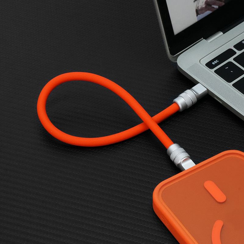 Orange short ChubbyCable charging smartphone from laptop