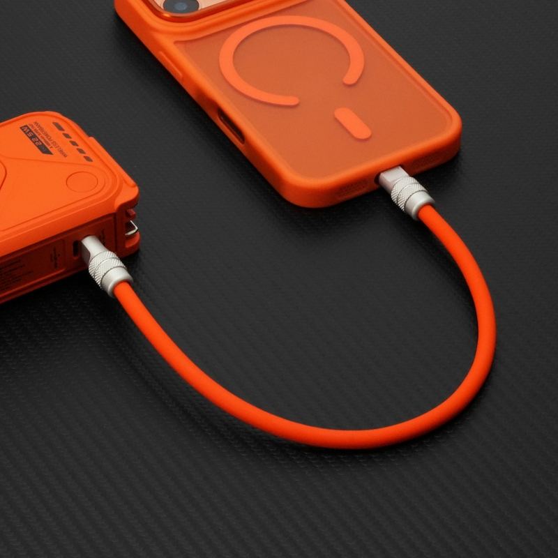 Short orange ChubbyCable connecting power bank to phone