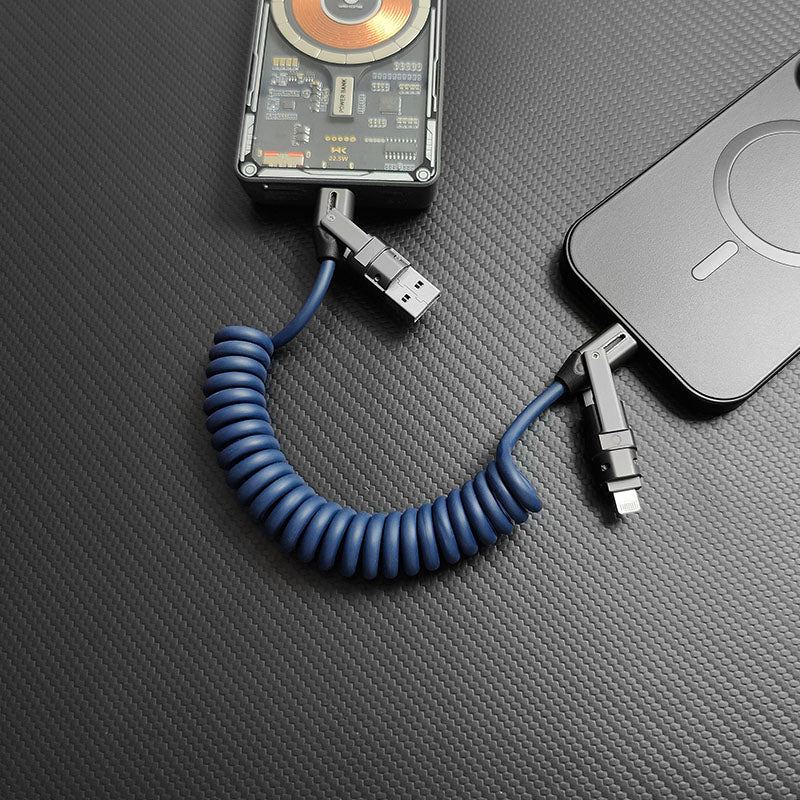 Blue coiled universal cable with metallic connectors charging a mobile device.