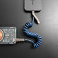 Blue coiled multi-functional charging cable connecting power bank to device.