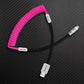 Pink coiled charging cable with black straight section