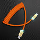 Orange coiled USB-C to USB-C cable with glowing connectors