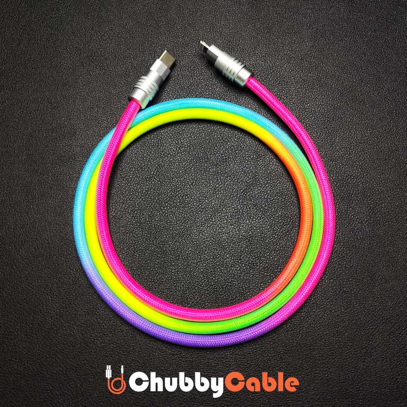 Coiled rainbow braided USB type C to Lightning cable on black background.