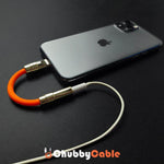 ChubbyCable orange USB-C audio adapter plugged into a smartphone with headphones connected.