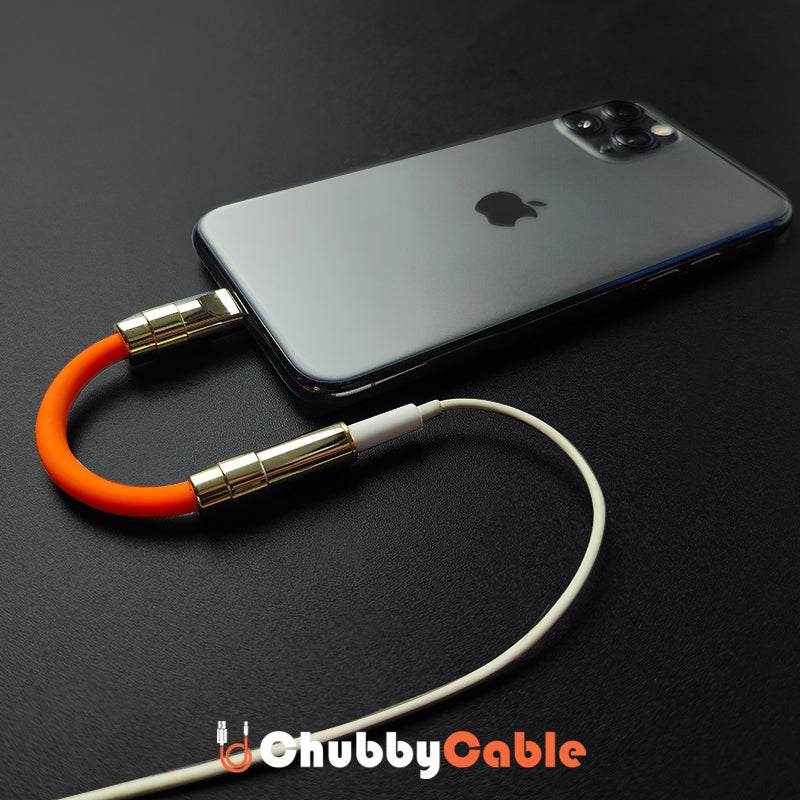 ChubbyCable orange USB-C audio adapter plugged into a smartphone with headphones connected.