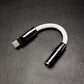 White USB C to 3.5mm headphone jack adapter with gunmetal alloy shell.