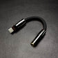 Matte black USB-C to 3.5mm headphone adapter with gunmetal hardware.