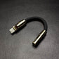 Matte black USB-C to 3.5mm audio jack adapter with gold metallic hardware.