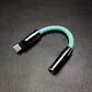 Mint green USB-C to 3.5mm headphone adapter with gunmetal hardware.