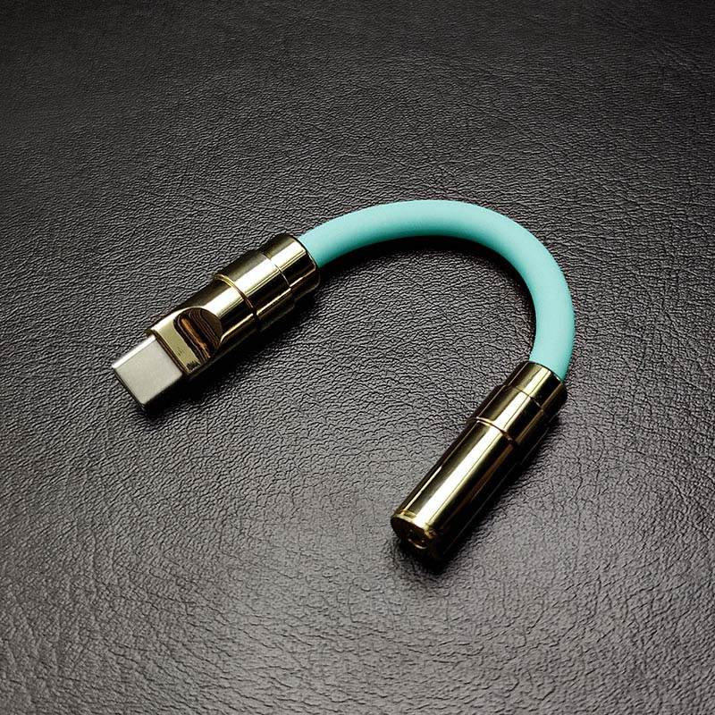 Mint green USB-C to 3.5mm audio jack adapter with gold hardware.