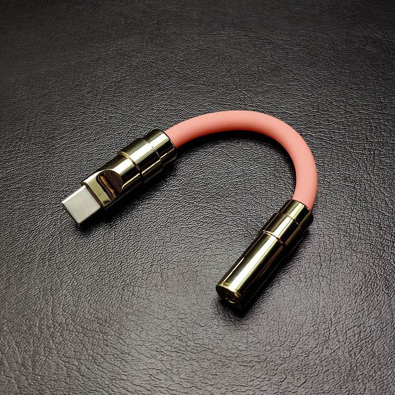 Pink silicone USB C to 3.5mm headphone jack dongle with gold metal connectors.