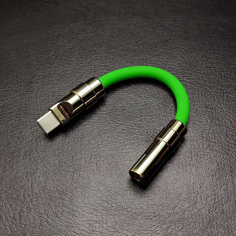 Bright green USB-C to 3.5mm audio jack adapter with gold hardware.