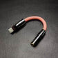 Pink USB-C to 3.5mm auxiliary audio cable adapter with gunmetal shell.